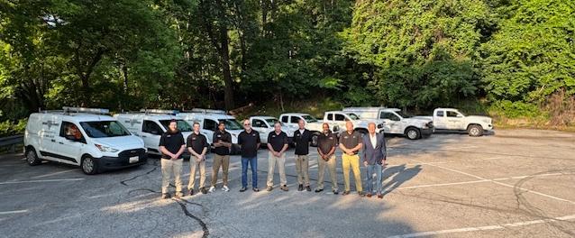 the atlantic pest control team standing in front of their fleet